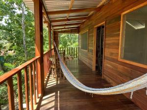 a hammock on the porch of a cabin at Hotel Mon Ami in El Remate