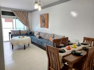 a living room with a blue couch and a table at Apartment in the city center, 2 minutes walk from the tram in Rabat
