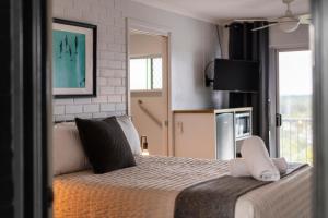 Un dormitorio con una cama grande y un televisor. en Yamba Views Angourie Room 11, en Yamba 17 fotos más