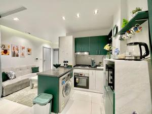 a kitchen with green cabinets and a stove top oven at Studio House 589-1 in 6th Of October