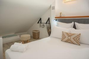 a bedroom with a large white bed with white pillows at Studio Mare Gaillard in Le Gosier