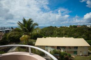 a view from a balcony of a building with a palm tree at Studio Mare Gaillard in Le Gosier