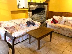 uma sala de estar com um sofá e uma mesa de centro em Cottage in the heart of the Ardennes woods em Harre