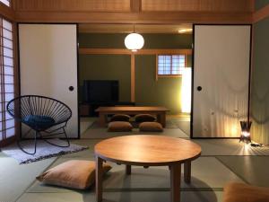 een woonkamer met een tafel en een kamer met een tv bij 金澤華ゆり in Kanazawa
