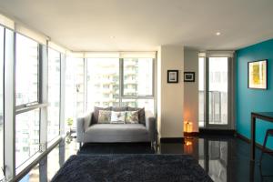 メルボルンにあるRelaxing, light-filled city apartmentのソファと大きな窓のあるリビングルーム +6枚の写真