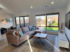 a living room with a couch and a table at Spacious 3-bedroom home close to town and beach in Saint Leonards