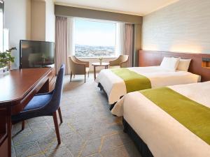 北九州市にあるリーガロイヤルホテル小倉のベッド2台とデスクが備わるホテルルームです。