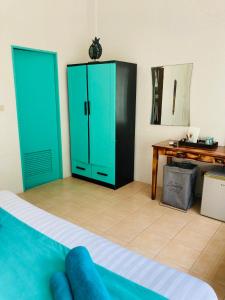 a room with a bed with green doors and a desk at Guest house Helene in Kata Beach