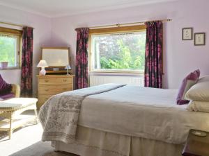 a bedroom with a large bed and a window at Sleepy Hollow - Smmc in Balmacara
