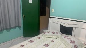 Cama en habitación con puerta verde en Pousada Da Lú, en Lençóis
