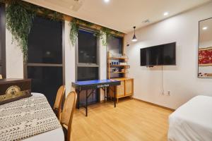 a room with a table and chairs and a tv at Hotel POCO Seongsu in Seoul