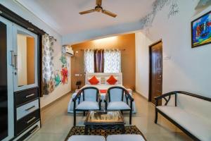 a room with a bed and two chairs and a table at Dewa Goa Hotel Near Dabolim Airport in Vasco Da Gama