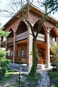a large brick building with a tree in front of it at U Yaroslava Hotel in Yaremche