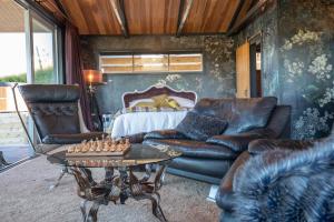 sala de estar con muebles de cuero y tablero de ajedrez en Holiday Bliss en Tirau