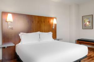 - un grand lit blanc dans une chambre d'hôtel dans l'établissement AC Hotel Alcalá de Henares by Marriott, à Alcalá de Henares