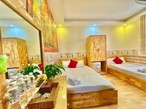 1 dormitorio con 2 camas, escritorio y espejo en Khách Sạn Minh Hà Đà Lạt en Dalat