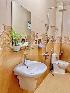y baño con lavabo, aseo y espejo. en Khách Sạn Minh Hà Đà Lạt, en Da Lat