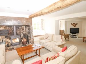a living room with a stone fireplace at West Henstill House in Crediton