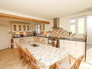 a kitchen with a table and chairs in a kitchen at West Henstill House in Crediton