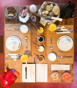 una mesa con platos, utensilios y comida. en Pousada Villa Madorna en Santana do Riacho