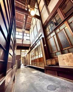 einen Flur in einem Gebäude mit Fenstern und einem Museum in der Unterkunft Inase Otsu Machiya Bed and Breakfast in Ōtsu