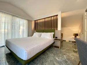 Un dormitorio con una gran cama blanca y una ventana en Salemare Rooms & Suites, en Cefalú