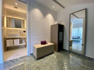 ein Badezimmer mit einem Spiegel, einem Stuhl und einem Waschbecken in der Unterkunft Salemare Rooms & Suites in Cefalú