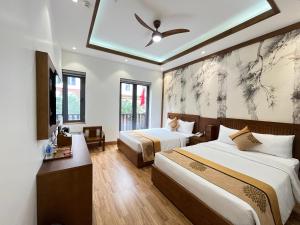 a hotel room with two beds and a ceiling fan at Samatha Hotel Bai Chay, Ha Long in Ha Long