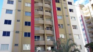 a tall apartment building with windows and palm trees at Prive das Thermas 405 in Caldas Novas