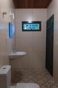 uma casa de banho com um lavatório, um WC e uma janela. em Pousada Villa Madorna em Santana do Riacho