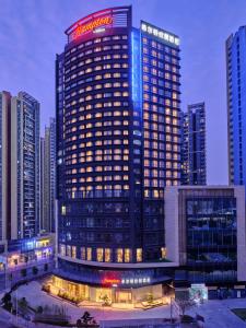 a tall building with a sign on top of it at Hampton by Hilton Shenzhen North Station in Shenzhen