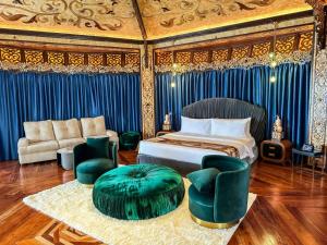 - une chambre avec un lit, un canapé et des chaises dans l'établissement Rancho Bernardo Luxury Villas and Resort, à Bagac