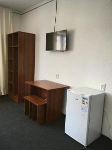 an office with a desk and a small refrigerator at Гостевой дом Крылья in Cholpon-Ata