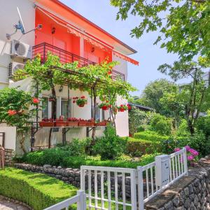 a house with a white fence in front of it at Apartments Katica in Selce