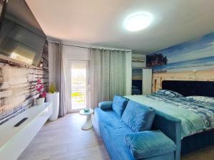 a bedroom with a blue bed and a couch at Apartments Katica in Selce