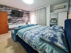 a bedroom with a bed and a tv on a wall at Apartments Katica in Selce