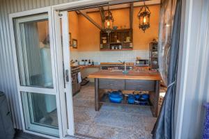 a kitchen with a wooden table and a sink at Holiday Bliss - Kiwi Suite in Tirau