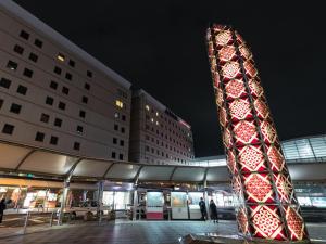 a tower in front of a building at night at JR Kyushu Hotel Kagoshima in Kagoshima