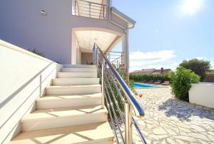 a staircase leading to a house with a pool at Villa Isabella in Linardići