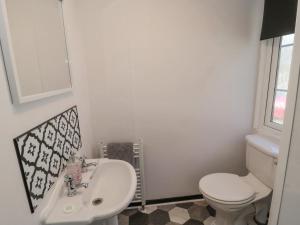 a white bathroom with a toilet and a sink at Betty's Lodge in Morpeth +15 photos