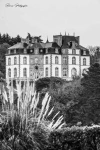 ein großes Haus auf einem Hügel in der Unterkunft Un appartement au château de Locquéran Finistère in Plouhinec