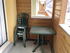 a green chair and a green chair sitting next to a window at Appartement cosy proche pistes avec parking - FR-1-292-195 in Isola