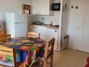 kuchnia ze stołem i białą lodówką w obiekcie Appartement bord de mer, 5 pers., animaux admis, parking, balcon équipé - FR-1-540-194 w mieście Notre-Dame-de-Monts +8 zdjęć