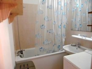 łazienka z zasłoną prysznicową i umywalką w obiekcie Appartement bord de mer, 5 pers., animaux admis, parking, balcon équipé - FR-1-540-194 w mieście Notre-Dame-de-Monts