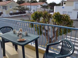 a table with a plate of food on a balcony at Notre-Dame-de-Monts (85) - Appartement de vacances 50m² environ - 4 personnes - FR-1-540-204 in Notre-Dame-de-Monts