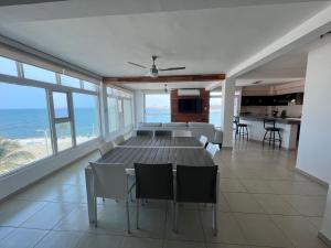 a dining room with a table and chairs and the ocean at FRENTE PLAYA vista al mar, PISCINA DE USO EXCLUSIVO in Boca del Río
