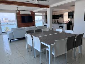 博卡德爾里奧的住宿－FRENTE PLAYA vista al mar, PISCINA DE USO EXCLUSIVO，一间带桌子和白色椅子的用餐室