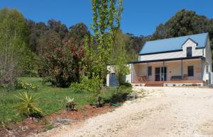 a small white house on a dirt road at Magpie Nest in Marysville +1 photo