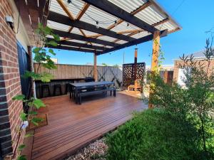 a patio with a bench and a table on a deck at Spacious 3-bedroom home close to town and beach in Saint Leonards