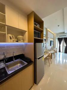 a kitchen with a sink and a refrigerator at Coast Residences Penthouse with skyline and manila bay view in Manila